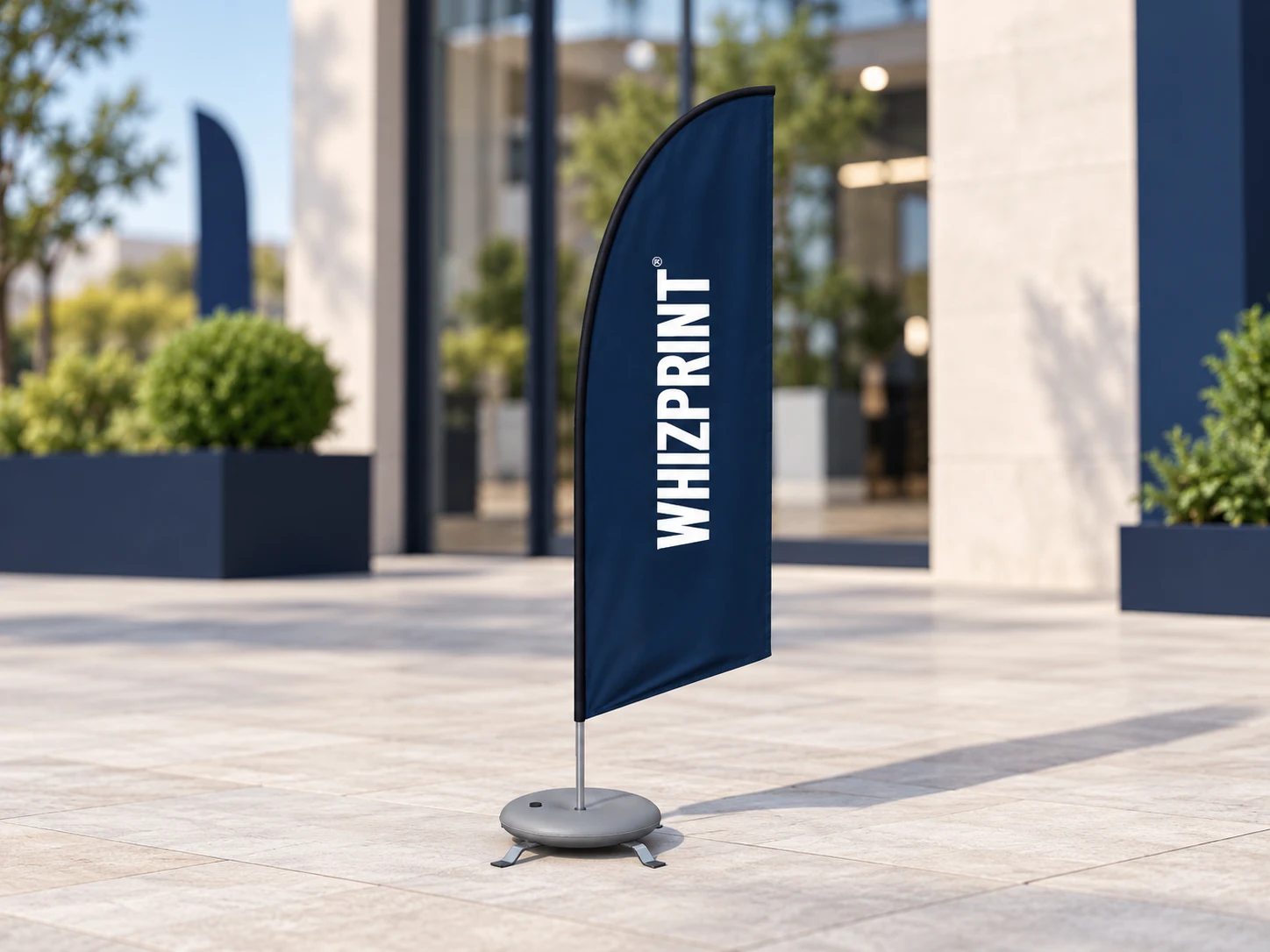 Navy Whizprint feather flag with white lettering kept inside the curved fabric outline, on a weighted base.