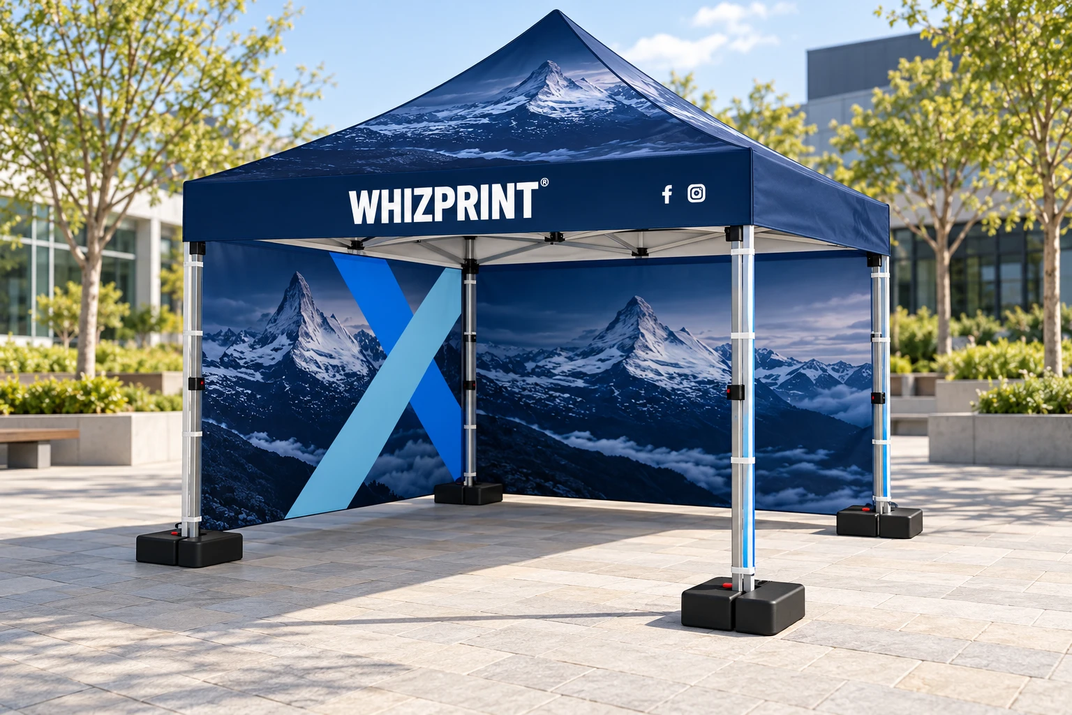 Navy and blue Whizprint gazebo viewed from its open corner, with two adjoining printed walls and weighted feet on paving.